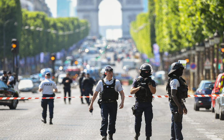 Police patrol the Champs-Elysees after a car crashed into a police van before bursting into flames.
