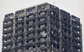 The charred remains of clading are pictured on the outer walls of the burnt out shell of the Grenfell Tower block in north Kensington, west London on June 22, 2017. 