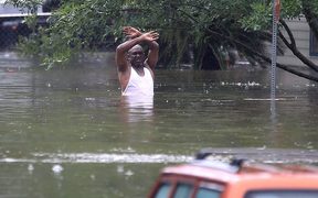 A man waves down a rescue crew as he tries to leave an area of Houston that has been swamped by floodwaters.