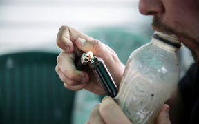 A male smoking using a homemade bong.