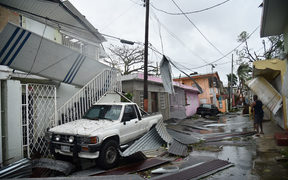 Residents of San Juan, Puerto Rico, deal with damages to their homes on September 20, 2017, as Hurricane Maria batters the island.