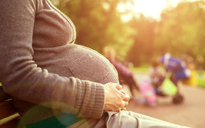 Pregnant woman sitting on a bench. 