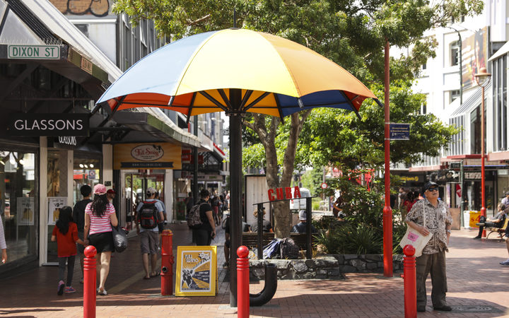 Summer in Wellington, Cuba Street. A man seeks shelter from the sun.