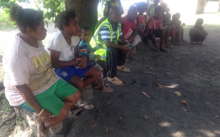 Vanuatu Emergency Medical Team's Dr Andy Ilo, (in vest) speaking with Ambae evacuee leaders.
