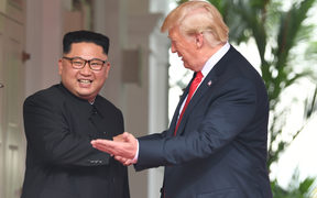 US President Donald Trump (R) gestures as he meets with North Korea's leader Kim Jong Un (L) at the start of their historic US-North Korea summit, at the Capella Hotel on Sentosa island in Singapore on June 12, 2018.