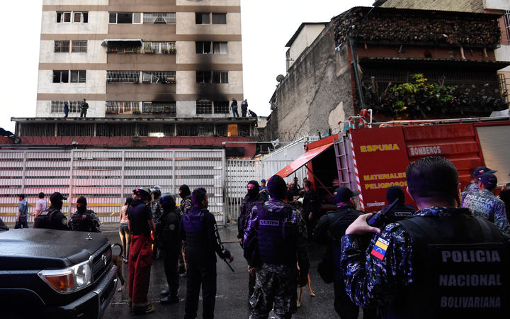 Security forces and members of the Bolivarian National Intelligence Service (Sebin) check a building after an explosion was heard near the place where Venezuelan President Nicolas Maduro was attending a ceremony to celebrate the 81st anniversary of the National Guard in Caracas