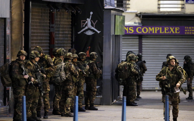 French army soldiers stand in position in the northern Paris suburb of Saint-Denis city center, on November 18, 2015, as French Police special forces raid an appartment, hunting those behind the attacks that claimed 129 lives in the French capital five days ago.