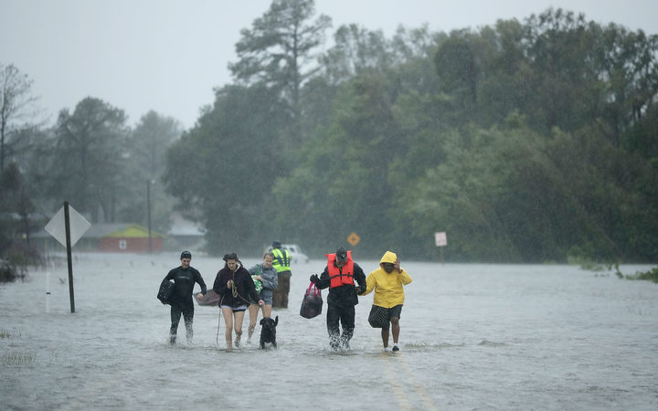 Volunteers from the Civilian Crisis Response Team help people to higher ground after rescuing them from their flooded homes during Hurricane Florence in James City, North Carolina. 