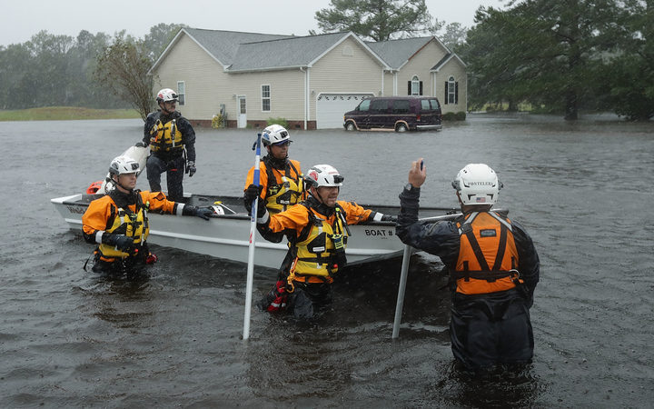 Members of the FEMA Urban Search and Rescue Task Force 4 from Oakland, California, search a flooded neighborhood for evacuees during Hurricane Florence in Fairfield Harbour, North Carolina.