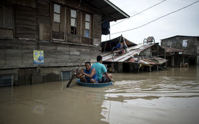 Men use a basin to cross a flooded street in the aftermath of Super Typhoon Mangkhut at Salonga Compound in Calumpit, Bulacan on September 16, 2018. 