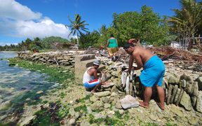 People of Kiritimati coral atoll building a stone seawall to struggle against sea level rise cause by global warming.