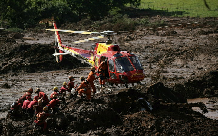 FILE - In this Jan. 28, 2019 file photo, firefighters are resupplied as they search for victims of the Vale dam collapse in Brumadinho, Brazil. 