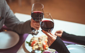 Couple sharing a meal and a glass of wine.