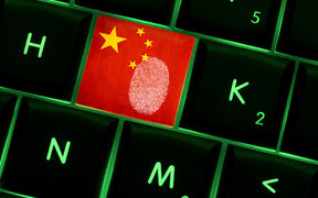 Online crime scene with a finger print left on backlit keyboard with Chinese flag on it
