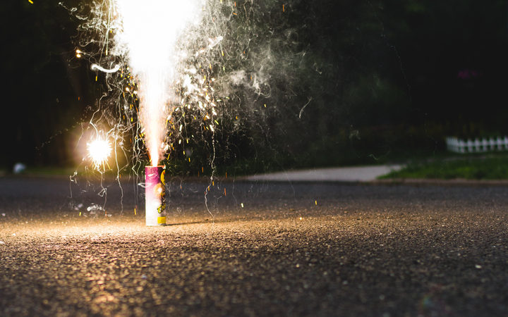 A small firework is set off on a street. 
