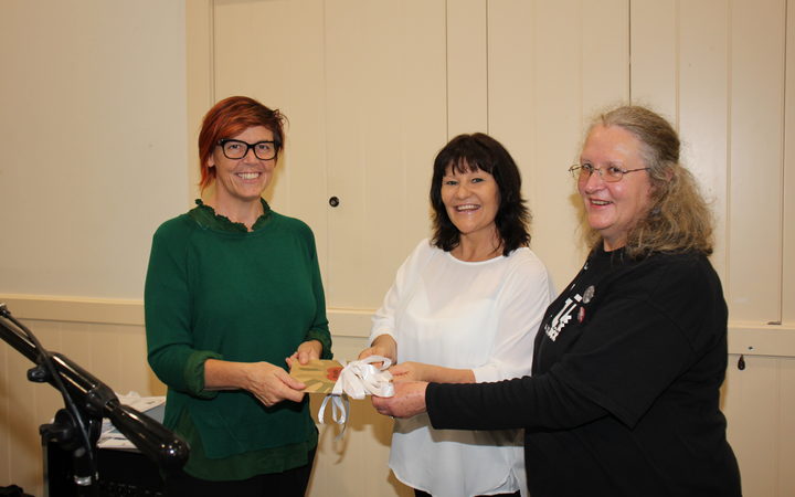 Greens Party senior citizens' spokesperson Jan Logie receiving a copy of the report, In Safe Hands? from Sacha Young (in white) and Marianne Bishop, of the National Aged Care Delegates Committee.