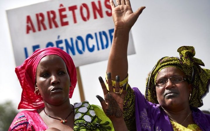 Malian women carry a banner 'Stop Genocide' as they take part in a march on in Bamako organised by the Mouvement Peul, an organisation of ethnic Fulani people.