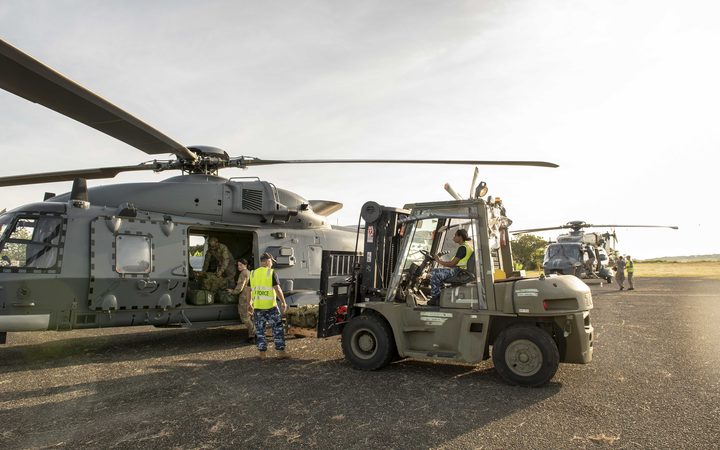 Members of the NZDF and ADF unload the NH-90 off the C17 in Honiara, Solomon Islands.