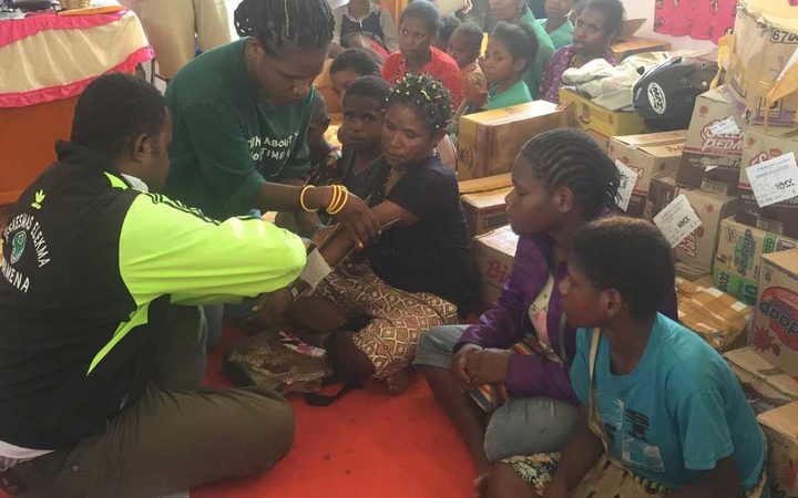 A volunteer doctor tends to a woman's broken arm, Wamena, Papua.