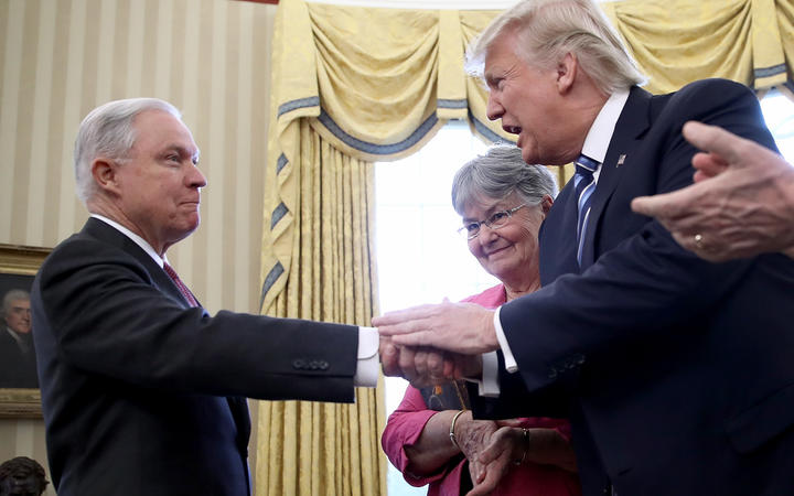 US President Donald Trump shakes the hand of Jeff Sessions after Sessions was sworn in as the new US Attorney General in 2017.