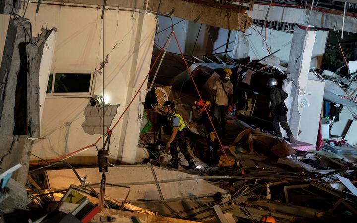 Rescue workers search for survivors in a collapsed Chuzon Super Market in Porac, Pampanga, after a powerful earthquake hit northern Philippines on April 22, 2019. 