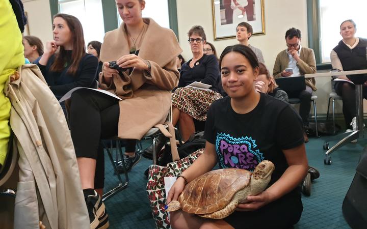 Waiata Rameka-Tupe with the dead New Zealand sea turtle named Tama Kahurangi, which had a stomach full of plastic, at packed Auckland Council meeting.