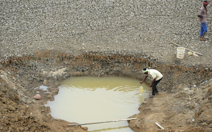 Indian workers collect water from the Puzhal reservoir on the outskirts of Chennai on June 20, 2019.
