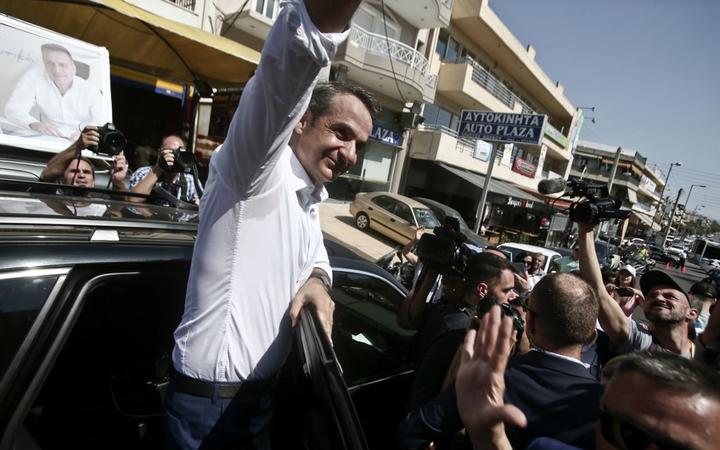 New Democracy leader Kyriakos Mitsotakis sallutes supporters.
