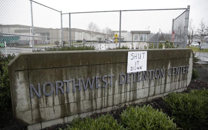A sign that reads "shut it down" is pictured at the Northwest Detention Center as people attend the Peoples Tribunal Against the Detention Center event in Tacoma, Washington on February 26, 2017. (Photo by Jason Redmond / AFP)