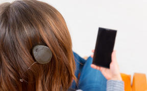 Deaf woman with cochlear implant using smartphone