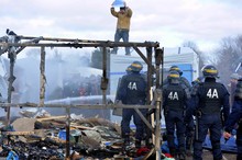 Camp occupants face anti-riot policemen at the Calais refugee camp.