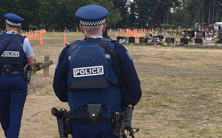 Armed police stand guard as Memorial Park Cemetery is prepared for the burial of victims of the Christchurch mass shooting.
