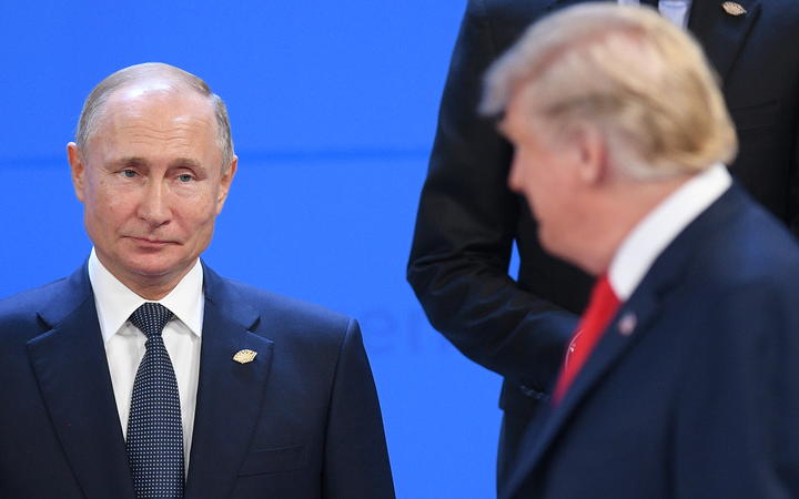 Russian President Vladimir Putin, left, looks at US President Donald Trump before posing for a family photo before the G20 summit in Argentina, 30 November, 2018.
