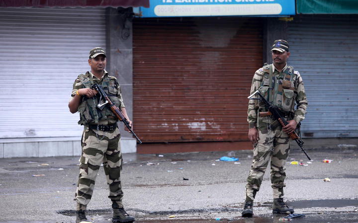 Security personnel stand guard on a street in Jammu.