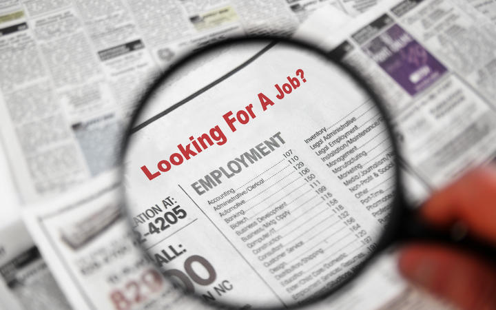 Magnifying glass over Jobs section of newspaper classifieds