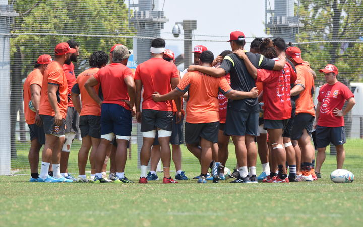 The 'Ikale Tahi players huddle together during training in Japan.
