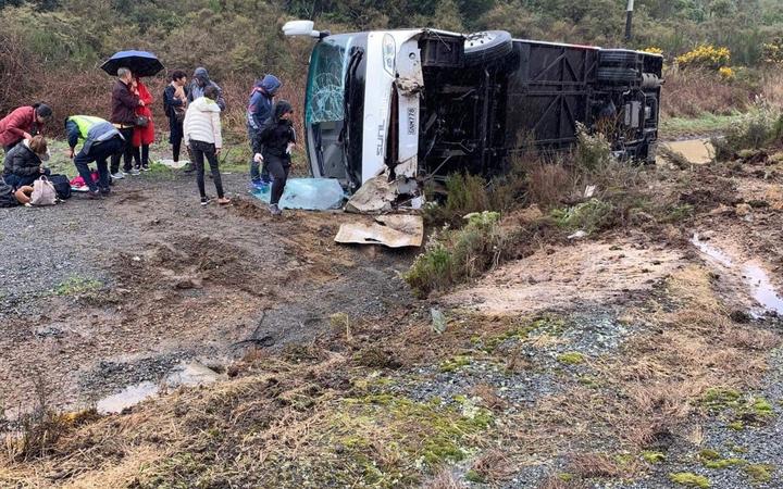 People support one another at the bus crash near Rotorua that has killed at least five people. 