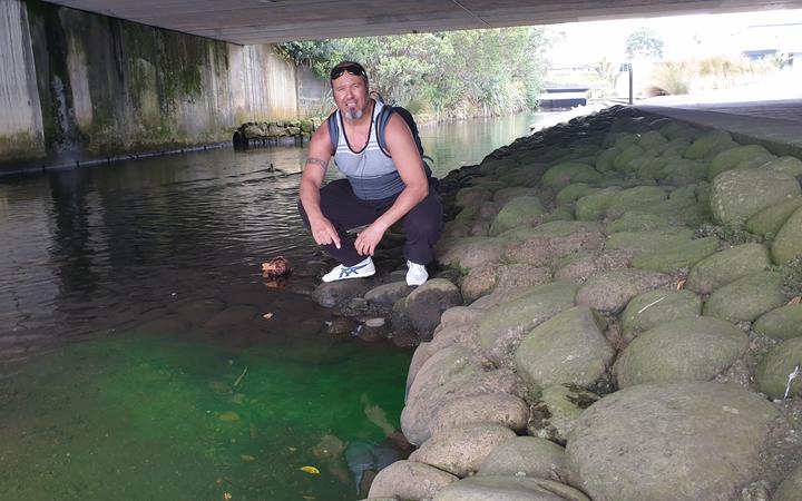 Aaron Tainui at the site of a luminous green discharge into the Huatoki Stream.