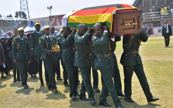 Soldiers in ceremonial uniform carry the casket of Zimbabwe's former President, the late Robert Mugabe after it arrived at Rufaro stadium on September 13, 2019.