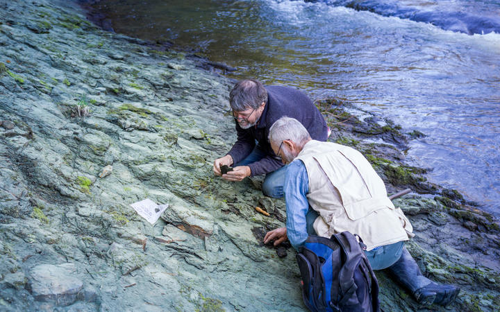 Dr Paul Scofield and amateur paleontologist Leigh Love examine a section of Waipara river bank, near where the fossil was found. 