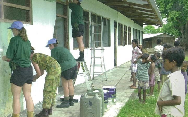 Personnel from No. 3 Squadron and 162 reconnaisance Squadron painting Holbelis village school.