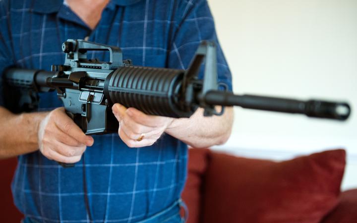 This February 4, 2013 photo illustration in Manassas, Virginia, shows a man holding a Colt AR-15 semi-automatic rifle.