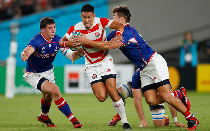 Japan's fly-half Yu Tamura (C) is tackled during the Japan 2019 Rugby World Cup Pool A match against Russia.