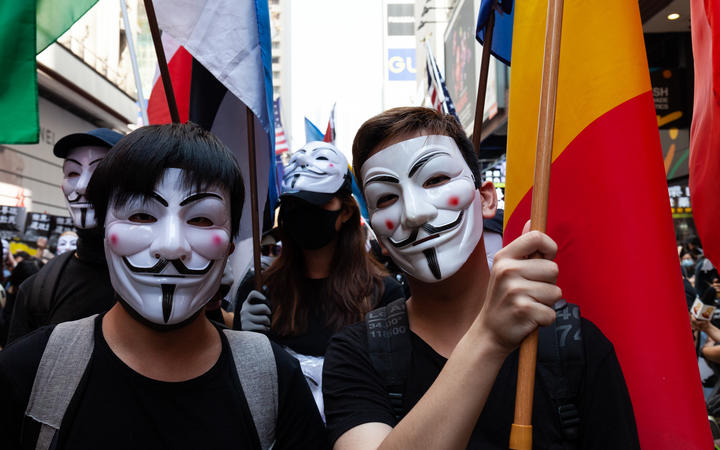 Hong Kong Protester wearing masks and marching with flags representing the countries that mentioned they support to Hong Kong protester, in Hong Kong, China, on October 1, 2019. 