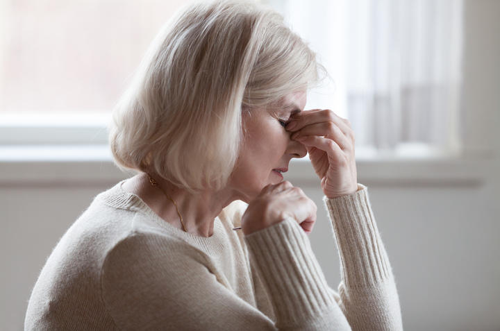 Fatigued older woman, headache, thinking, stress. (File photo)
