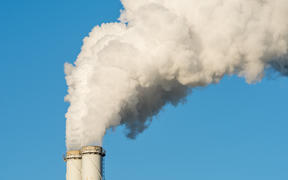 The pipe of a coal power plant with white smoke as a global warming concept.
