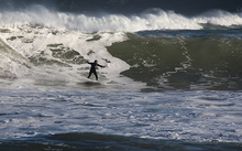 A surfer at Lyall Bay after a storm surge on 14 June 2015. 