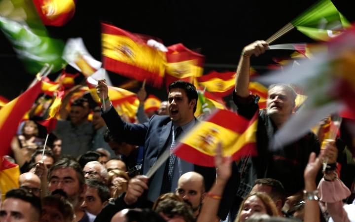 Supporters wave Spanish flags during a rally of Spanish far-right Vox part.