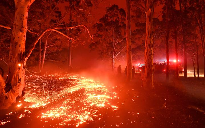 Burning embers cover the ground as firefighters battle against bushfires around the town of Nowra in the Australian state of New South Wales on December 31, 2019. 