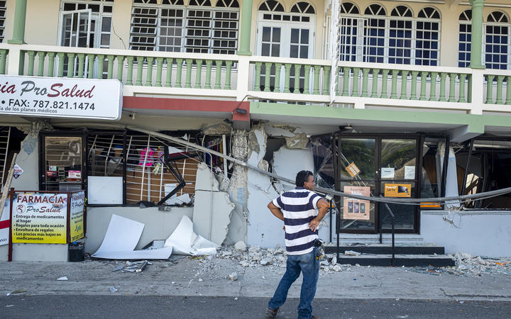A man surveys a collapsed businesses after an earthquake hit Guanica, Puerto Rico on January 8, 2020.